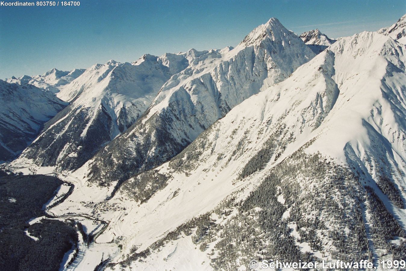 Siedlung im Talgrund: Lavin (Position: 2'804'123.21, 1'183'104.85); linker Bildrand Mitte: Susch, von dort ins Tal 'Val Susasca' Richtung Flüela-Pass nach Davos. - Bergspitze oberer Bildrand: Piz Linard, rechts daneben: Piz Chapisun.